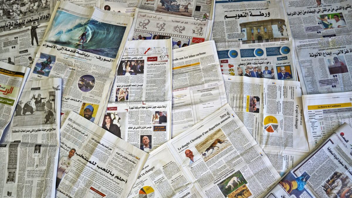 Gazety i notatnik dziennikarski na biurku redakcyjnym